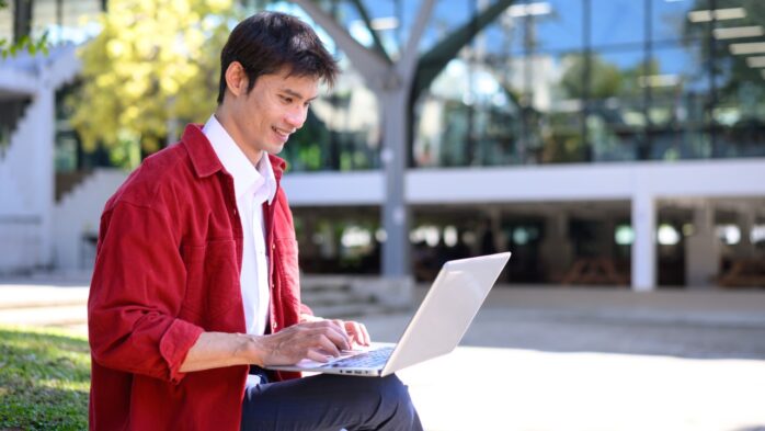 Remote administrative assistant working on a laptop outdoors managing business tasks