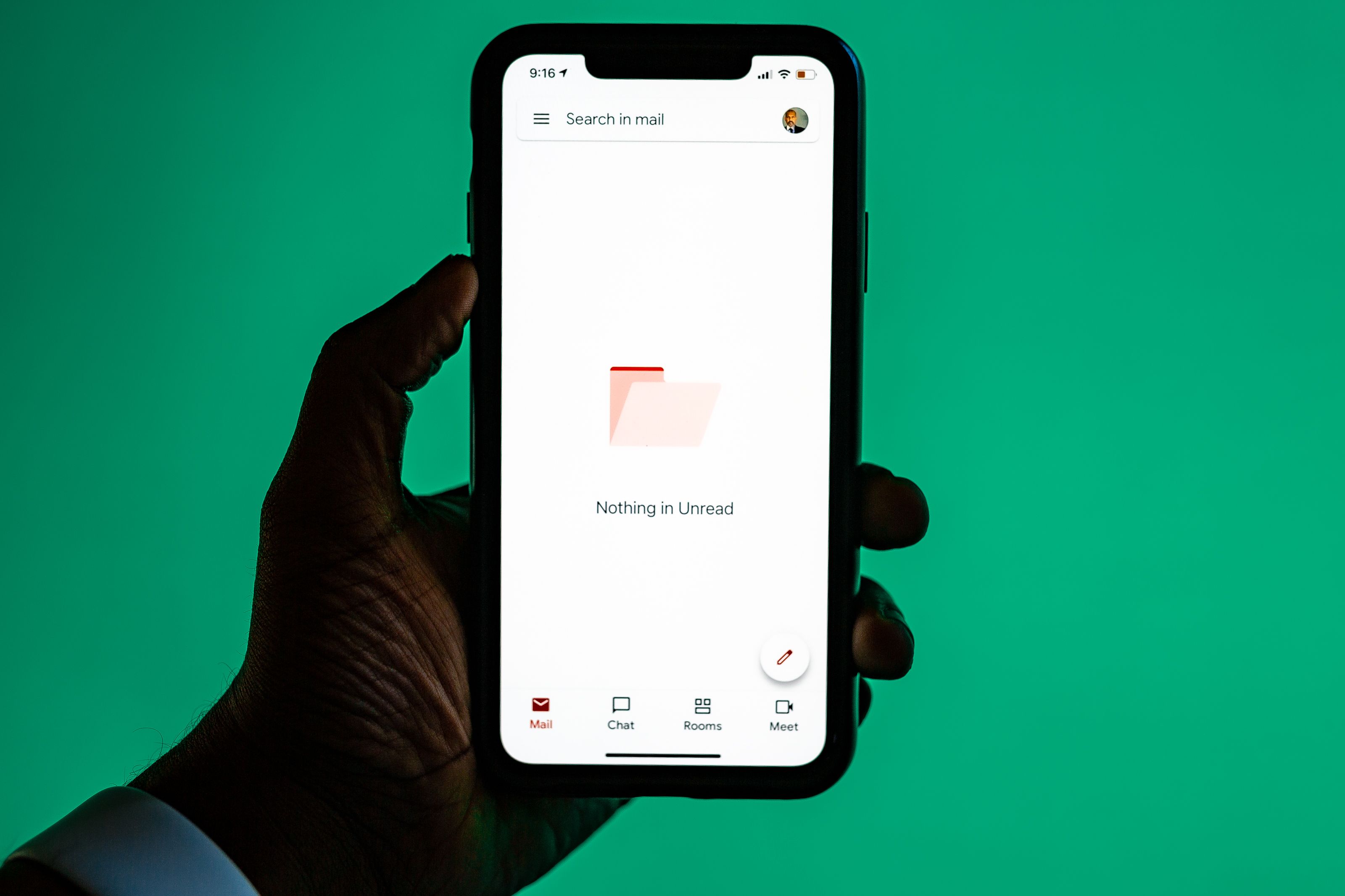 Hand holding a smartphone showing an email app, illustrating faster email writing with AI