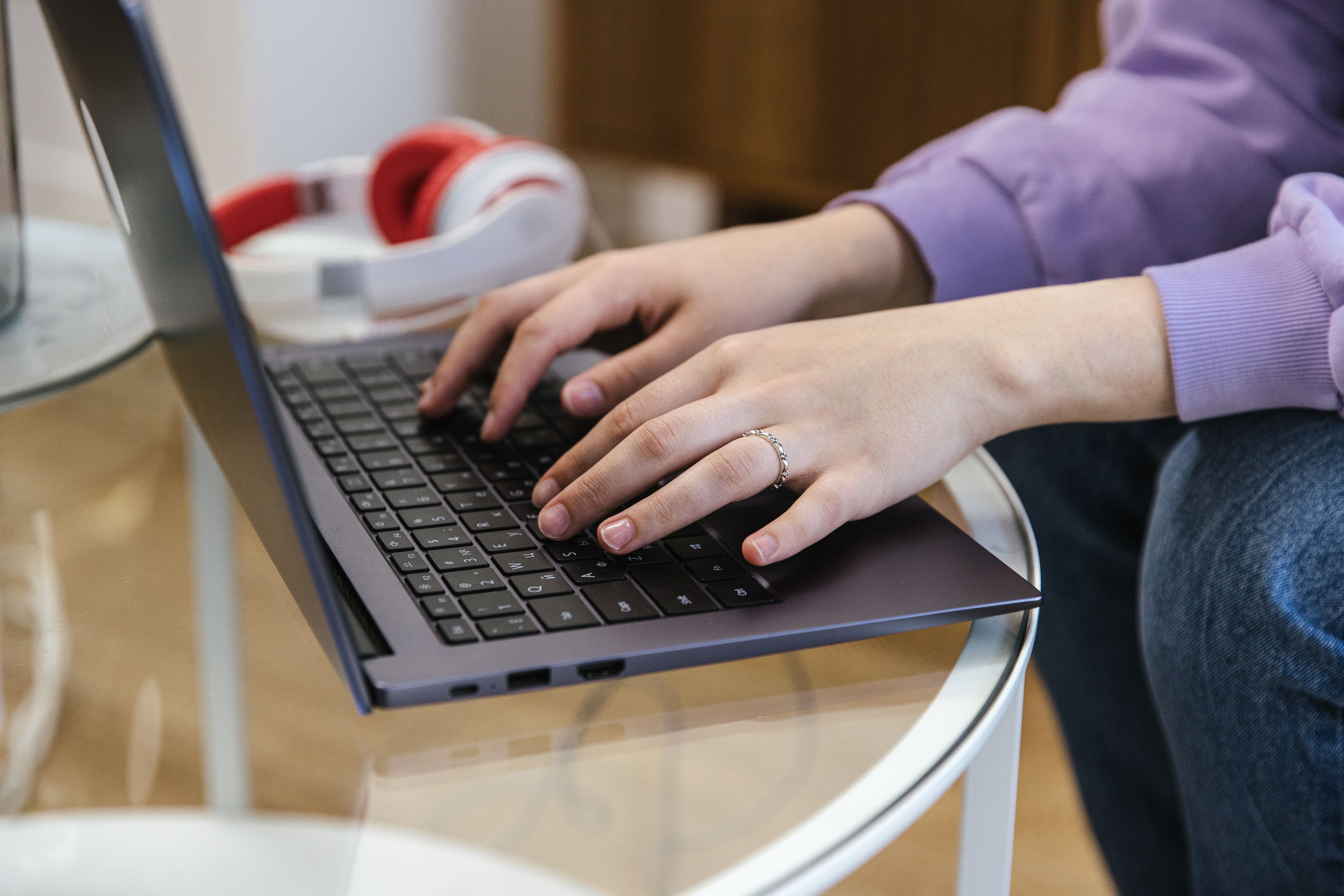 Close-up of hands typing on a laptop, symbolizing the hours saved by AI paraphrasing tools